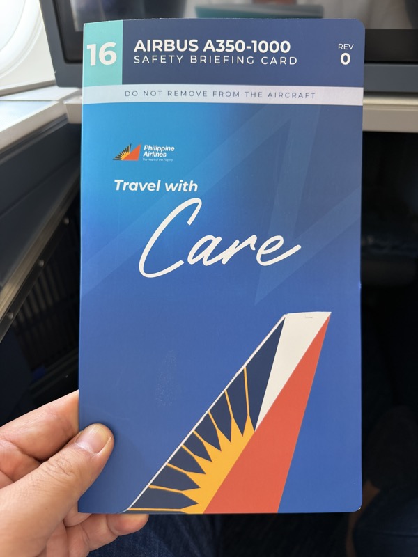 a hand holding a blue and white brochure