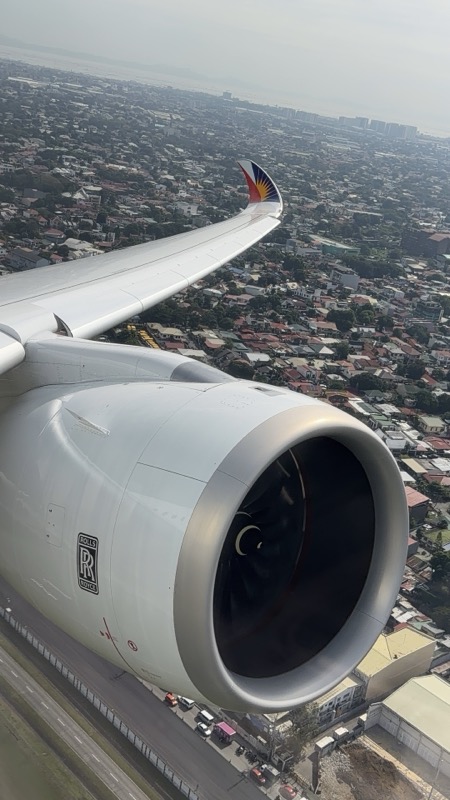 an airplane wing with a city in the background
