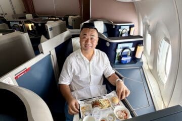 a man sitting in a chair with a tray of food