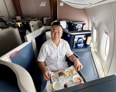 a man sitting in a chair with a tray of food