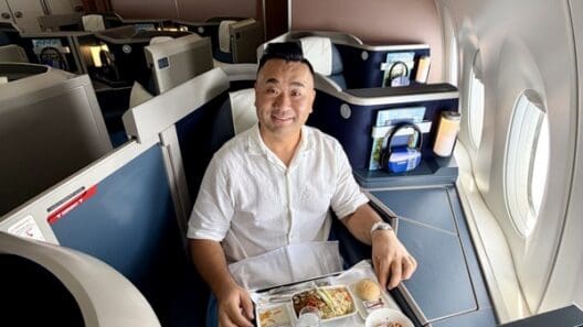 a man sitting in a chair with a tray of food