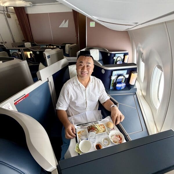 a man sitting in a chair with a tray of food